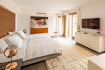 A bedroom with two beds and a flat screen tv