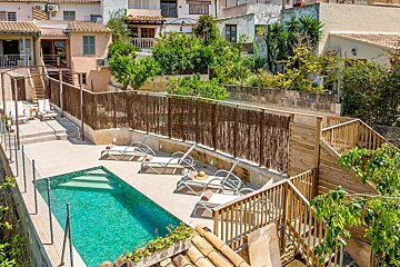 A large swimming pool surrounded by chairs and a fence