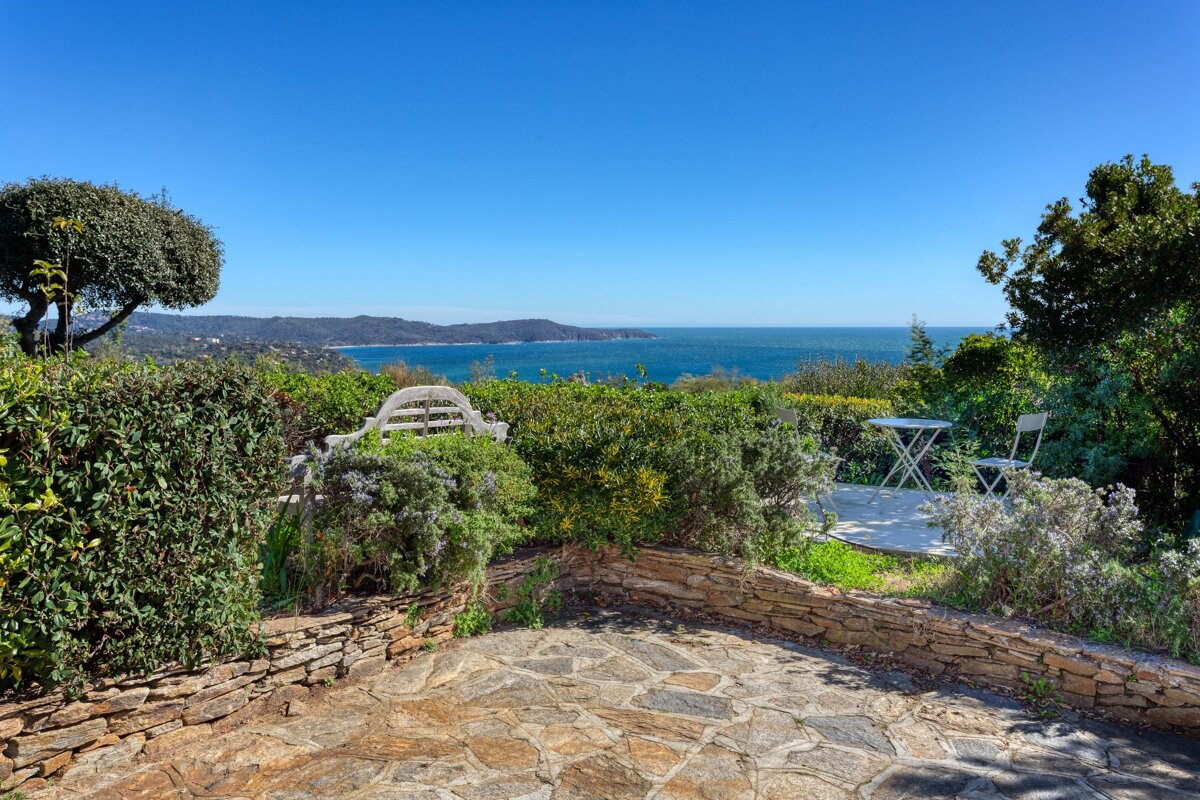 A patio with a table and chairs overlooking the ocean