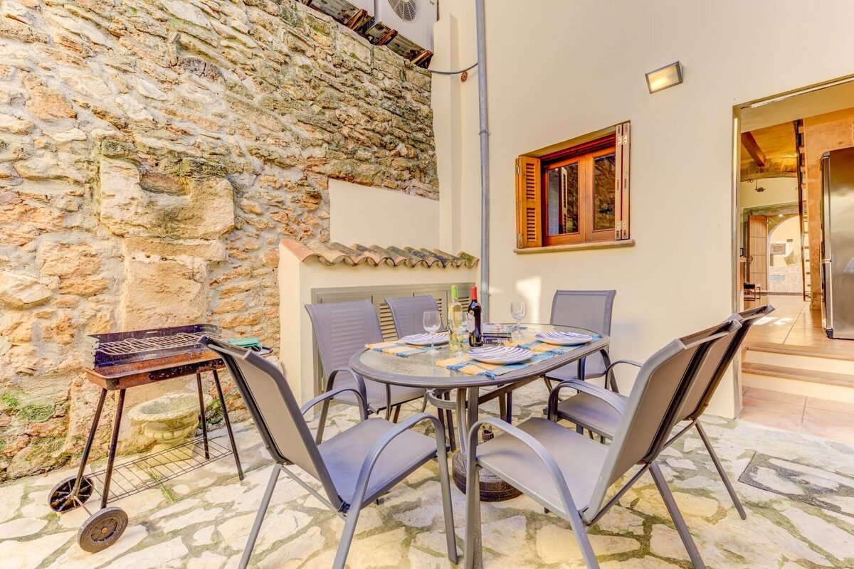 A table with four chairs and a bottle of wine on it