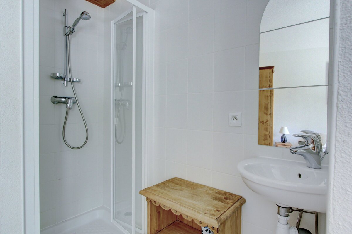 A bathroom with a sink a shower and a mirror