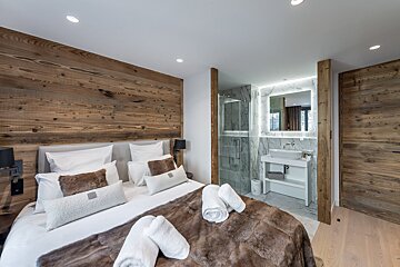 A bedroom with a bed and a bathroom with a sink
