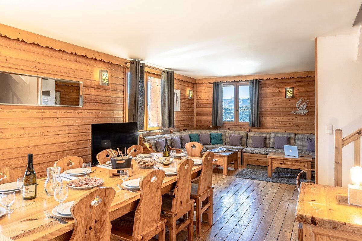 A living room with a wooden table and chairs