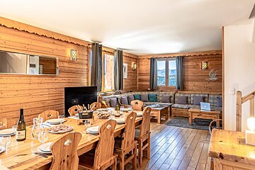 A living room with a wooden table and chairs