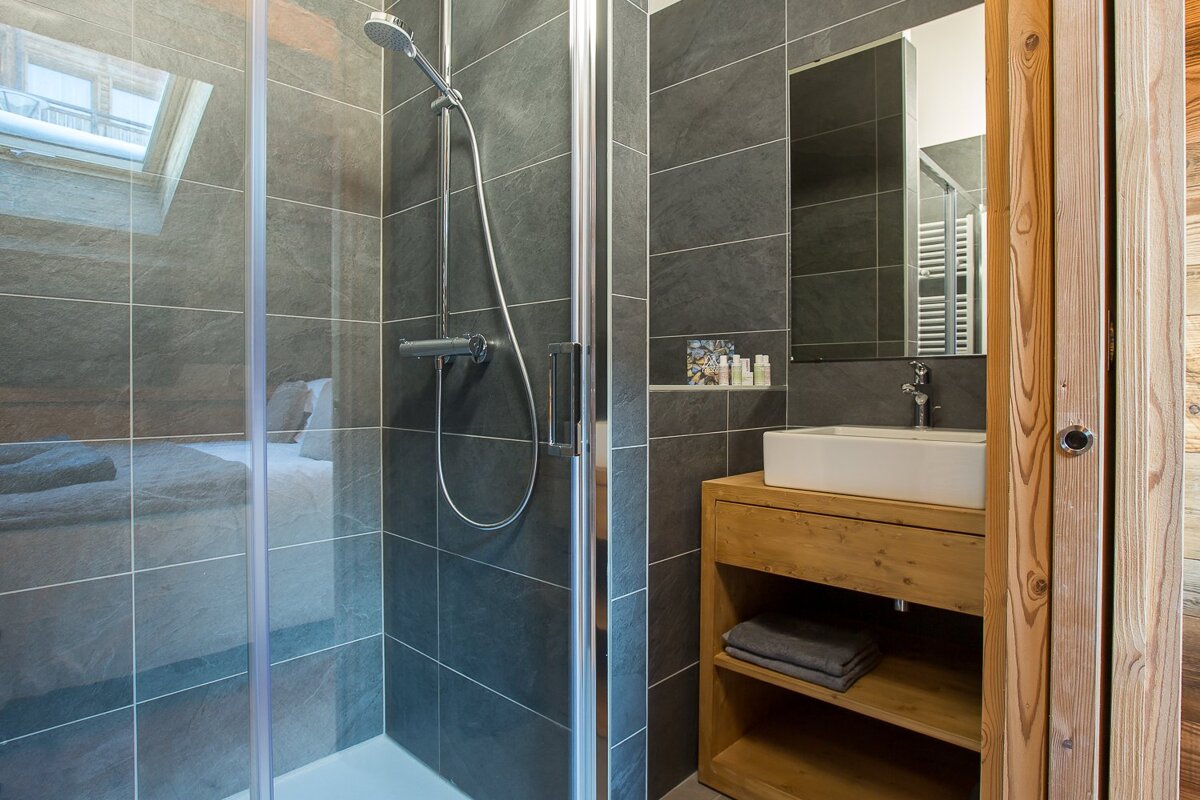 A bathroom with a walk in shower and a sink