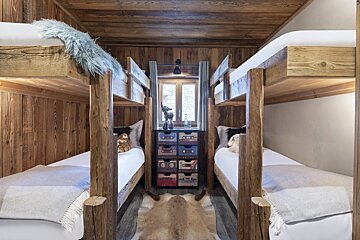 A room with bunk beds and a shelf with cassette tapes on it