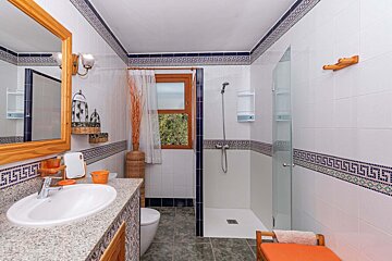 A bathroom with greek key tiles and a walk in shower