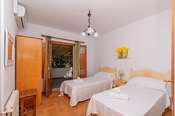 A bedroom with two beds and a picture of flowers on the wall