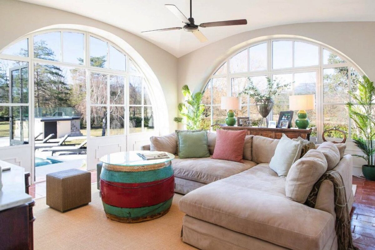 A living room with a couch a table and a ceiling fan