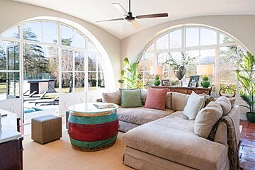 A living room with a couch a table and a ceiling fan