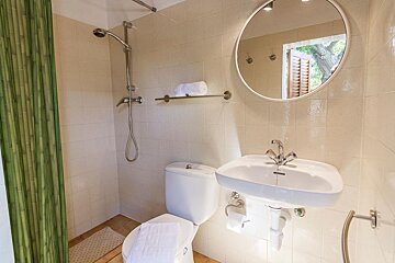 A bathroom with a toilet a sink and a mirror