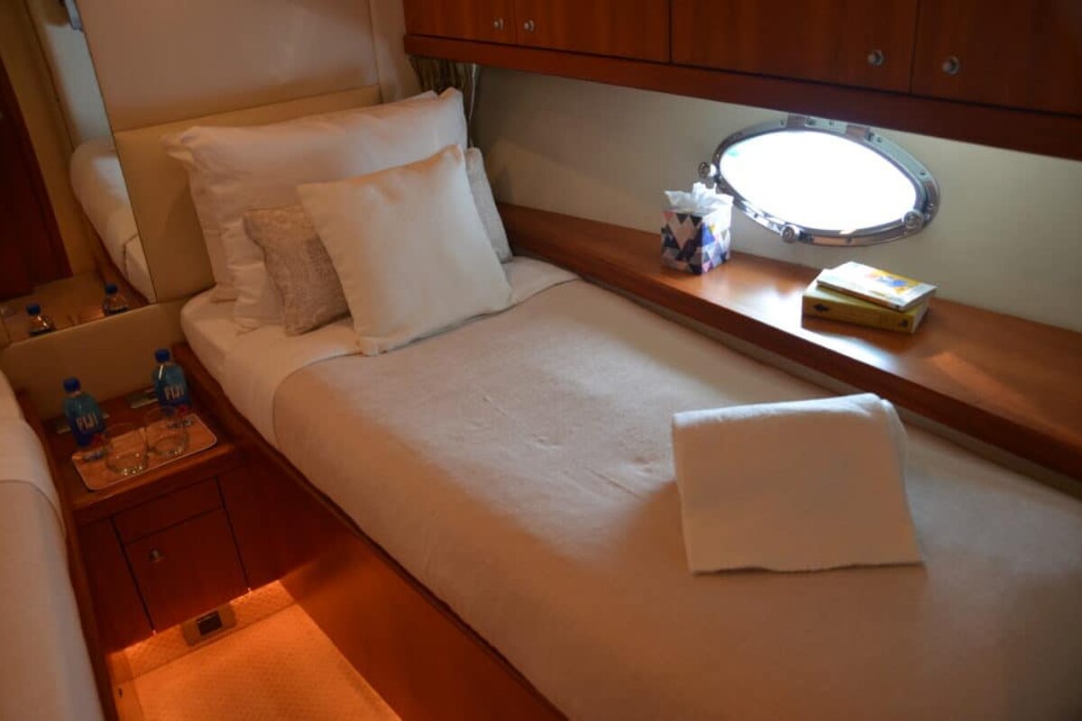 Two bottles of aquafina water sit on a nightstand next to a bed