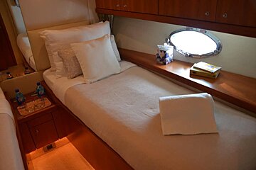 Two bottles of aquafina water sit on a nightstand next to a bed