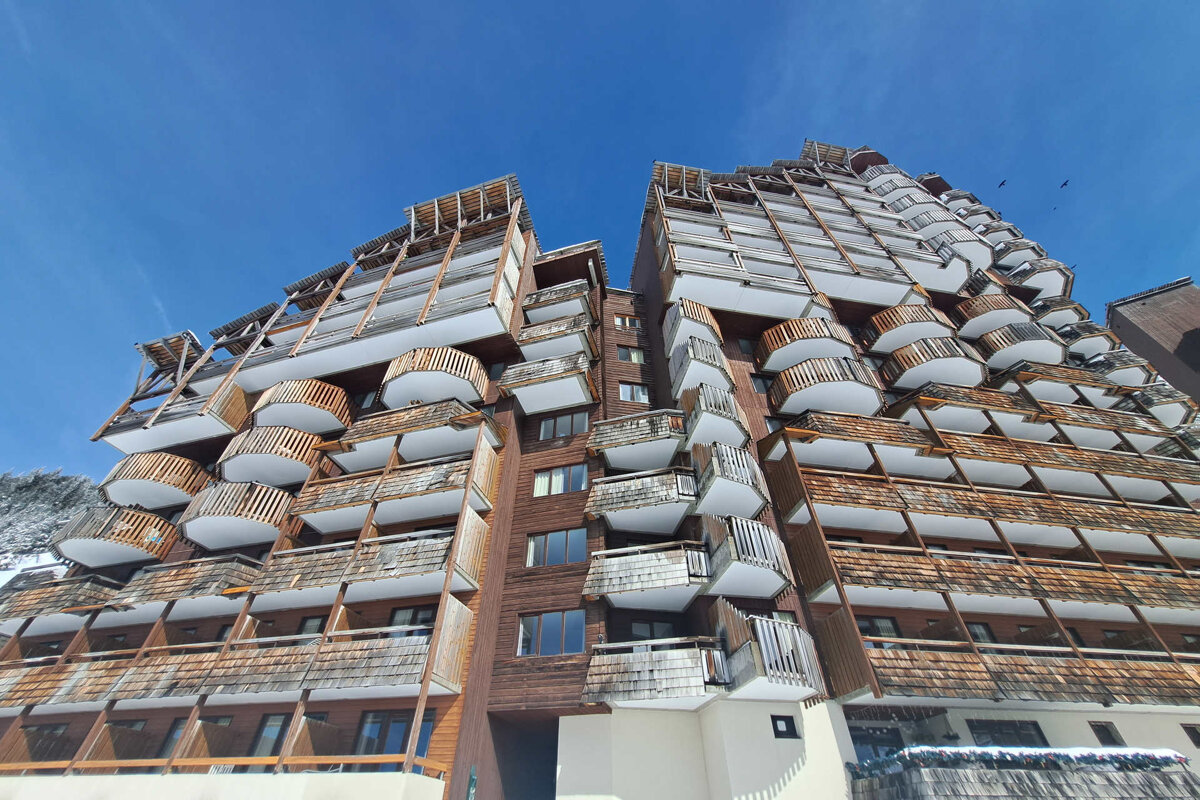 Looking up at a tall building with lots of balconies