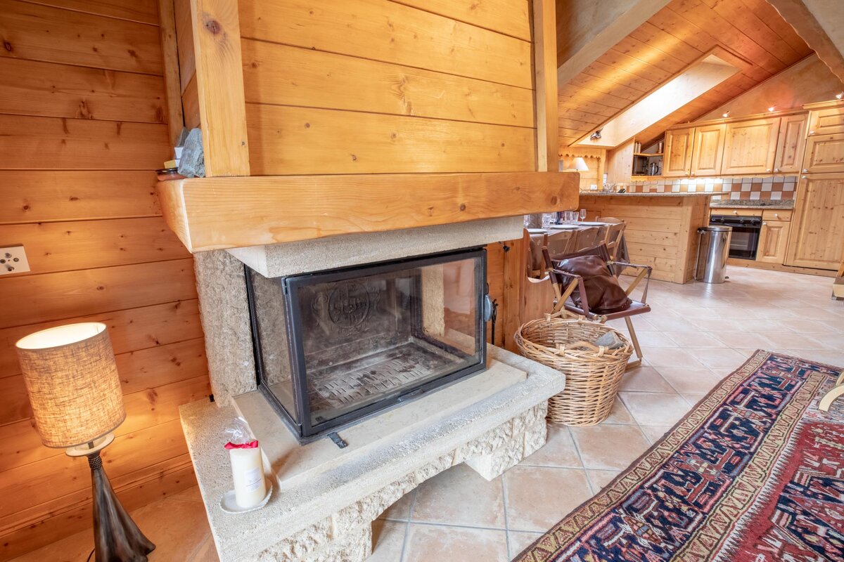 A fireplace in a wooden cabin with a candle on it