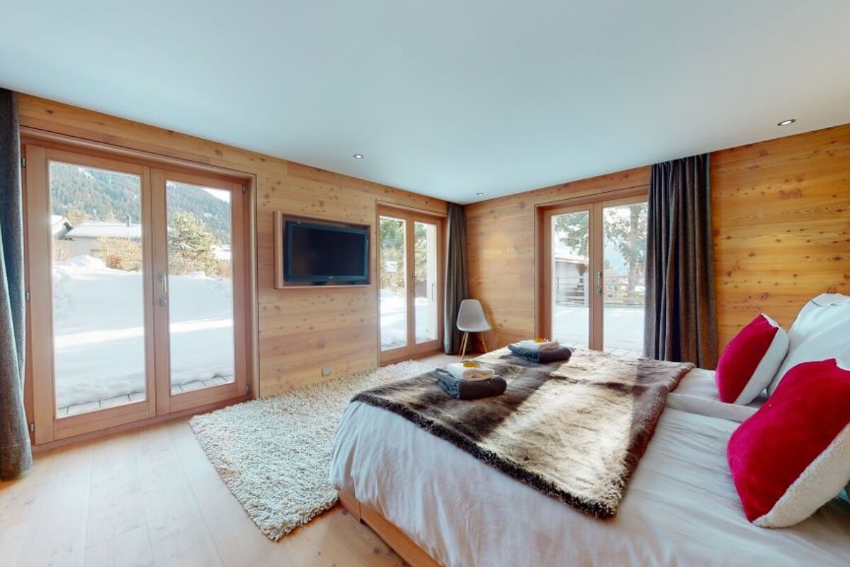 A bedroom with a large bed and a flat screen tv