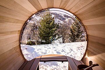 A view of a snowy forest from inside a sauna