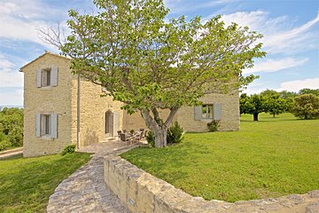 A stone house with a tree in front of it