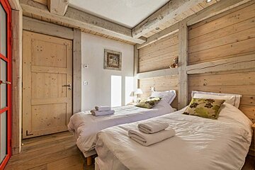 A bedroom with two beds and a red door