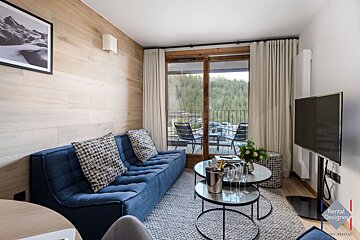 A living room with a blue couch and a flat screen tv