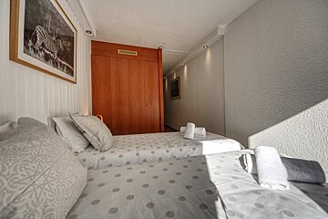 A bedroom with two beds and a picture of a zebra on the wall