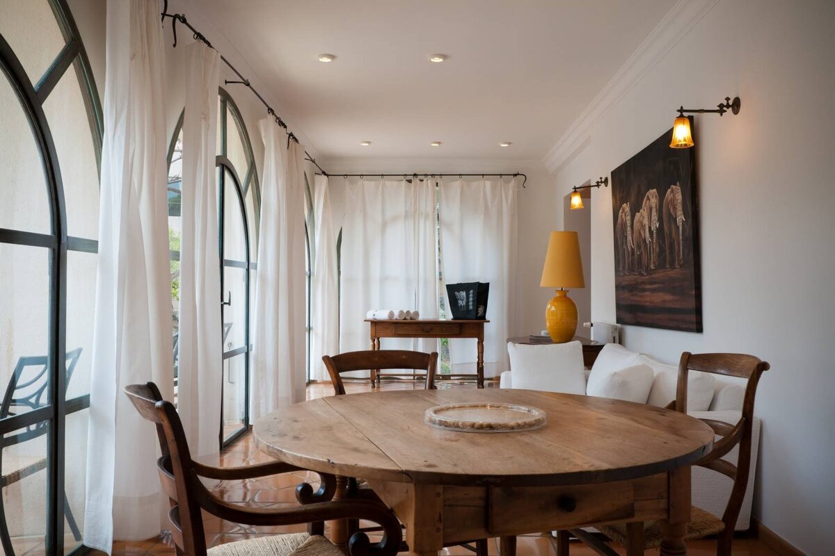 A room with a table and chairs and a painting on the wall