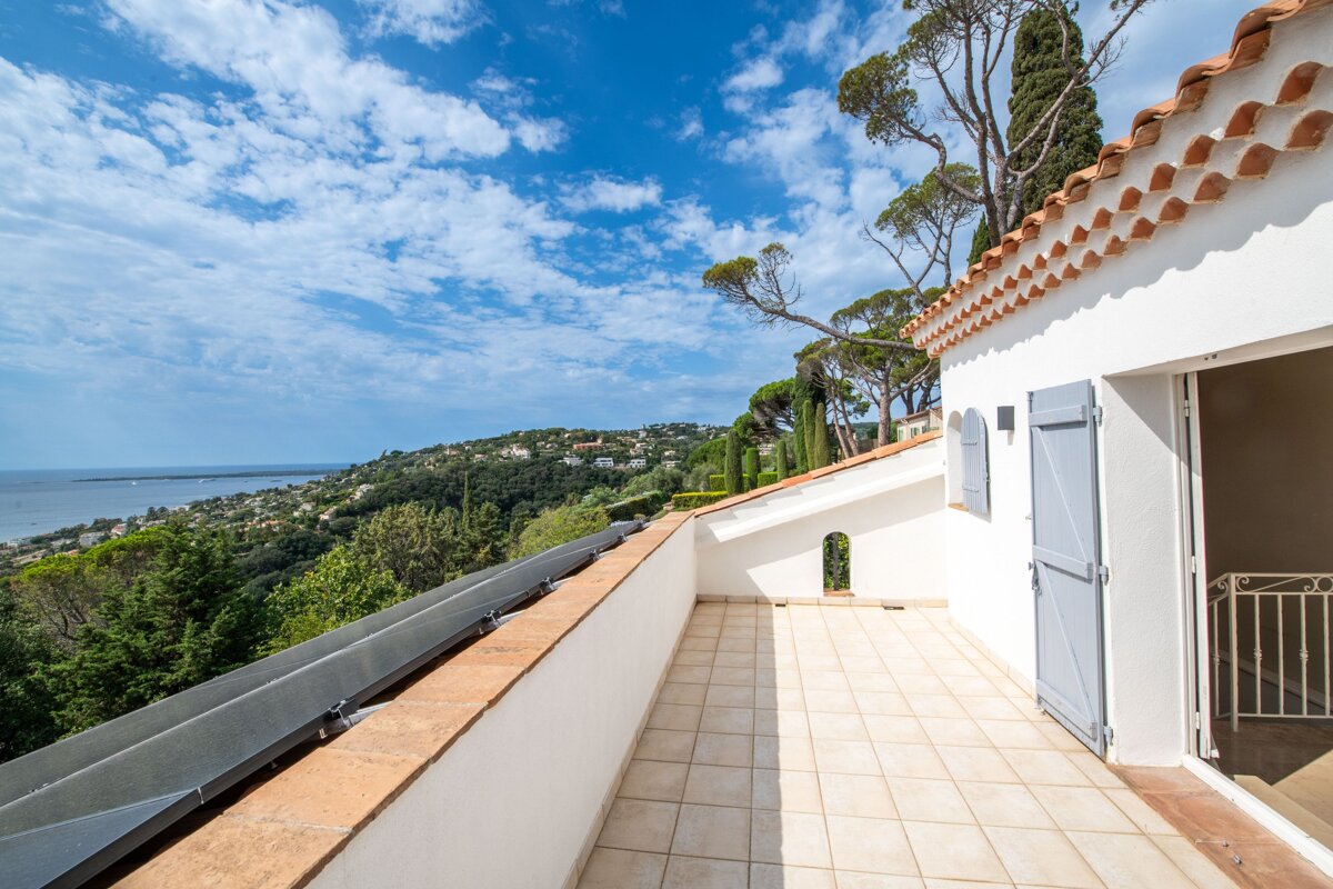 A balcony with a view of the ocean and trees