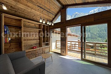 A living room with a couch and a table and the word maximmobile on the bottom