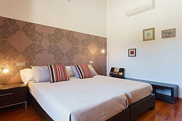 A bedroom with two beds and a picture on the wall