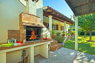 A barbecue is being cooked on a patio in front of a house
