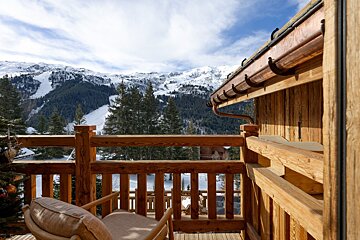 A wooden balcony with a view of snowy mountains