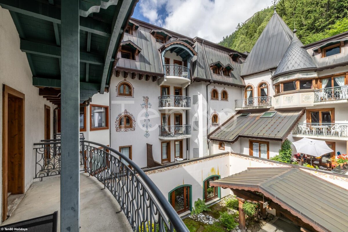 A balcony overlooking a courtyard with a castle shaped building in the background
