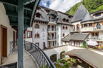 A balcony overlooking a courtyard with a castle shaped building in the background
