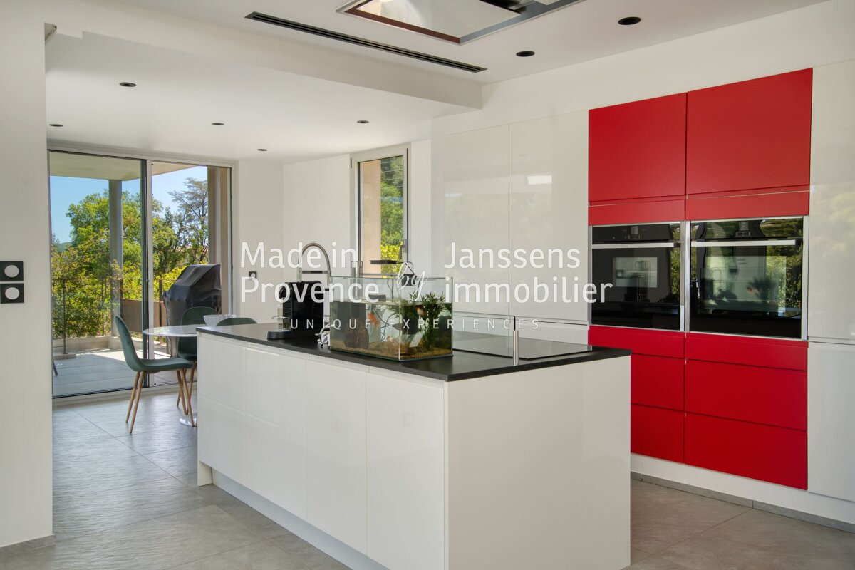A kitchen with red and white cabinets and the words made in janssens provence immobilier