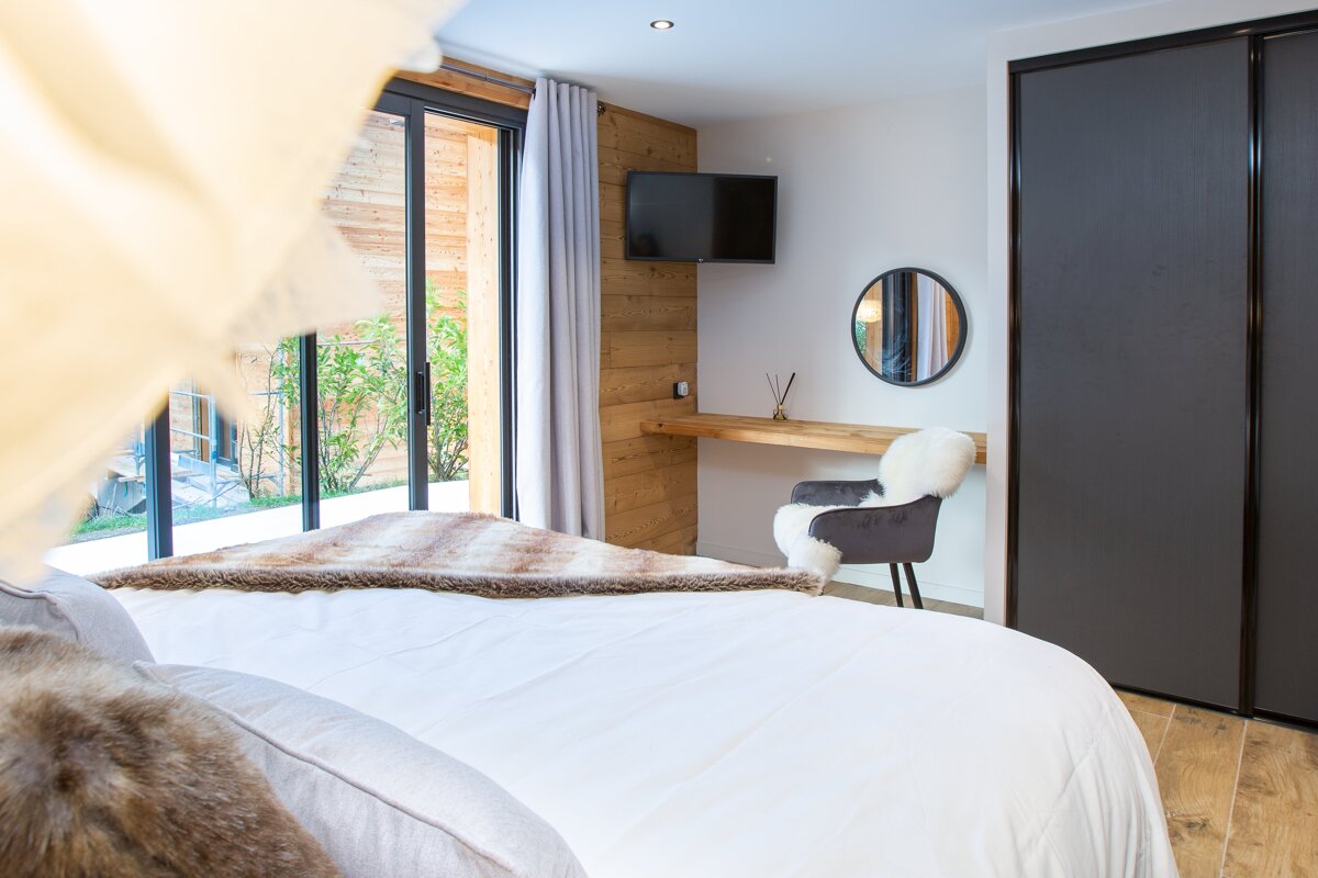 A bedroom with a bed a chair and a television