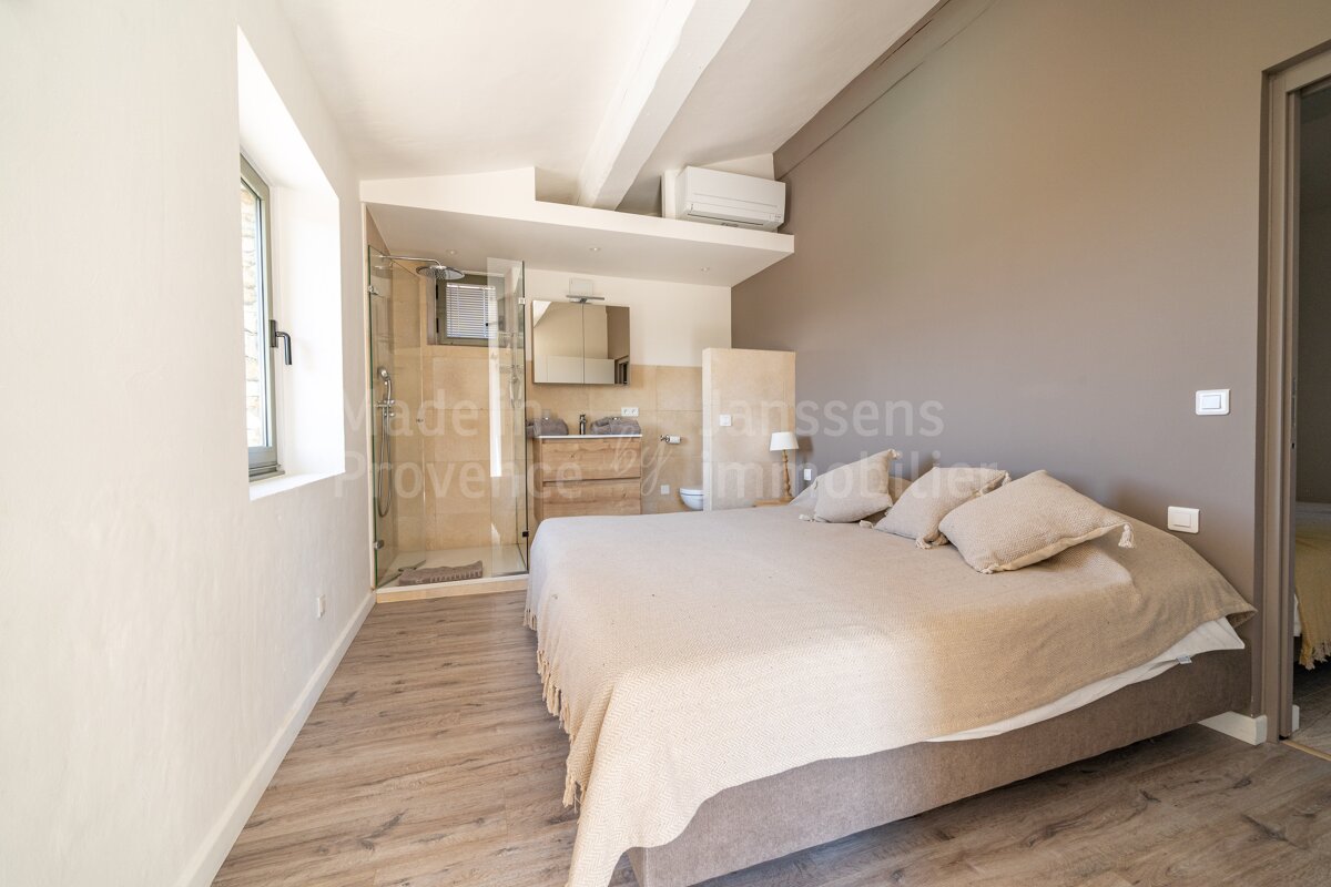 A bedroom with a large bed and a sign that says agence lanssens