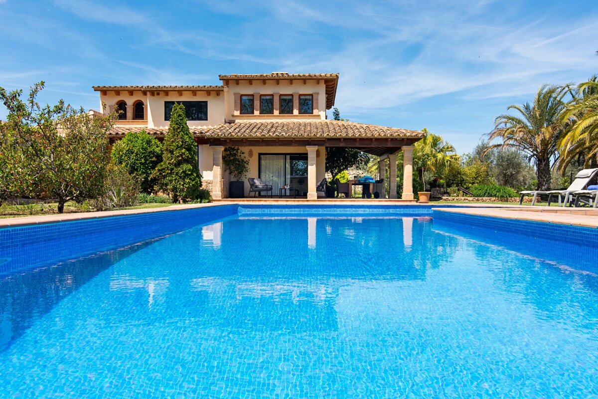A large house with a swimming pool in front of it