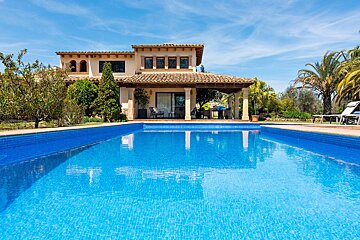 A large house with a swimming pool in front of it