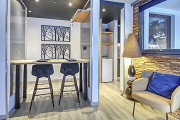 A room with a table and chairs and a lamp