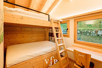 A wooden bunk bed with a ladder and the letters vjp on the bottom