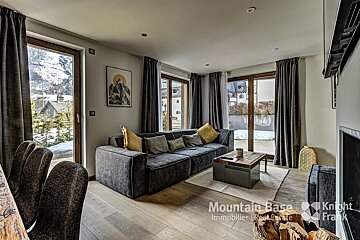 A living room with a couch a coffee table and a sign that says mountain base