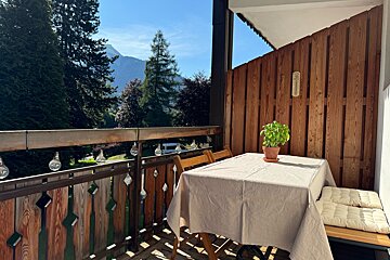 A balcony with a view of mountains and trees