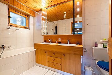 A bathroom with two sinks and a toilet