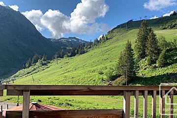 A balcony overlooking a lush green hillside with a sign that says a110