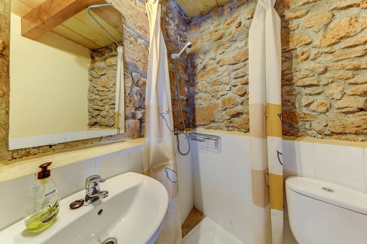 A bathroom with a sink a toilet and a shower curtain
