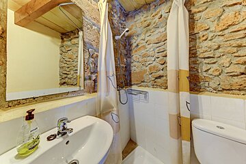 A bathroom with a sink a toilet and a shower curtain