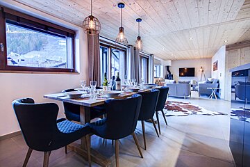 A dining room table with a bottle of wine on it