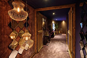 A hallway with a purple carpet and mirrors on the wall