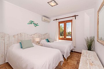 A bedroom with two beds and a mirror
