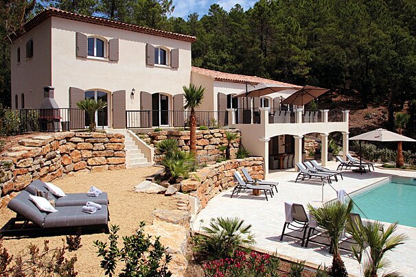 A large house with a swimming pool in front of it